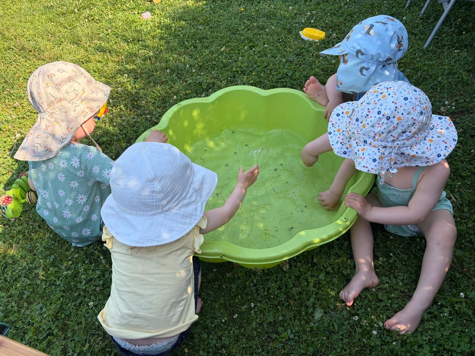 Kinder spielen mit Wasser im Garten