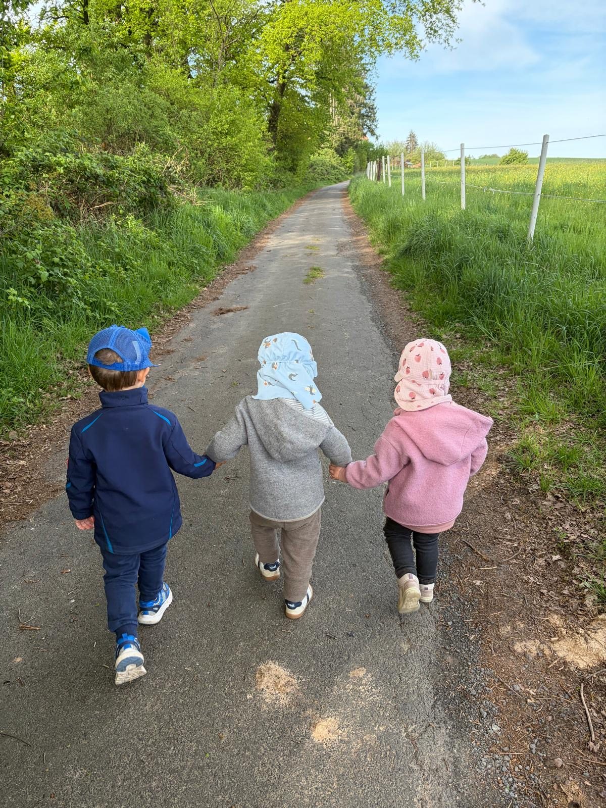 Kinder gehen gemeinsam einen Feldweg entlang